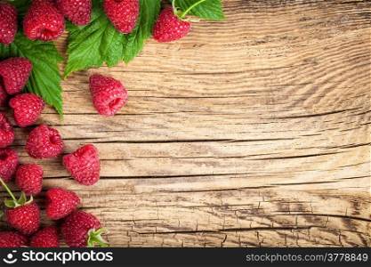 Raspberries on wooden table background. Copy space. Top view
