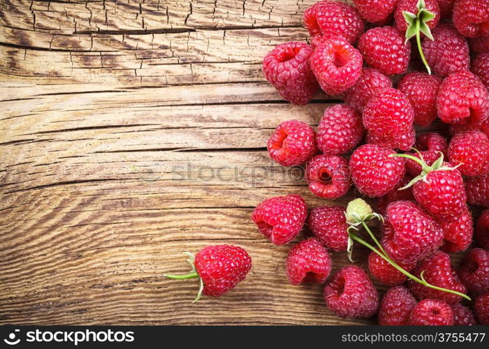 Raspberries on wooden table background with copy space. Top view&#xA;