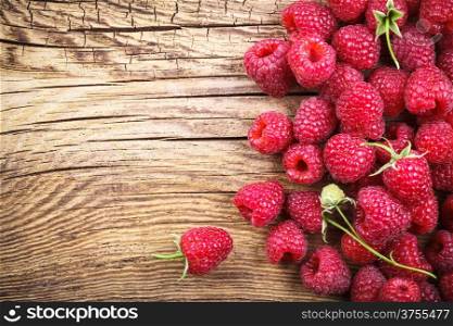Raspberries on wooden table background with copy space. Top view&#xA;