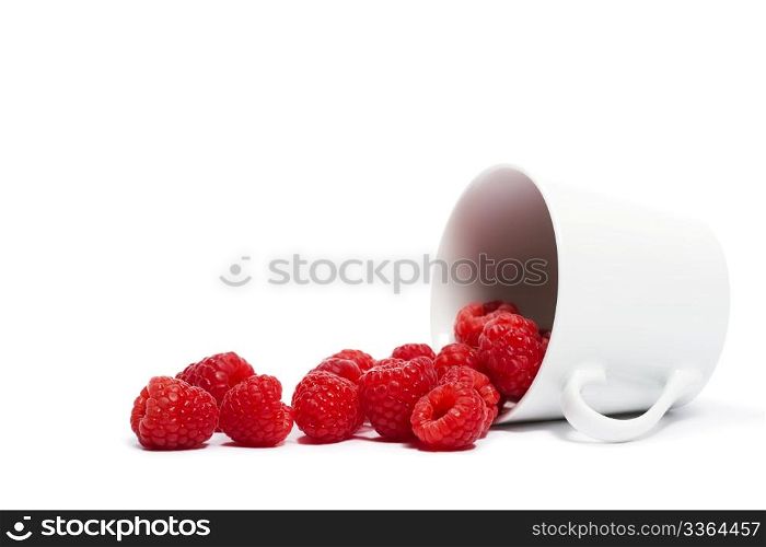 raspberries rolling from a fell over cup. raspberries rolling from a fell over cup on white background