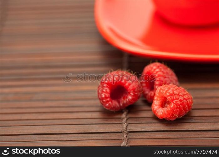 raspberry cup and saucer on a bamboo mat