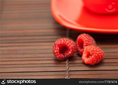 raspberry cup and saucer on a bamboo mat