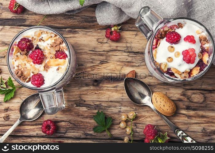 Raspberry ice cream in mug. Raspberry ice cream with almonds and currants in glass cup.Sundae on a vintage rustic background.