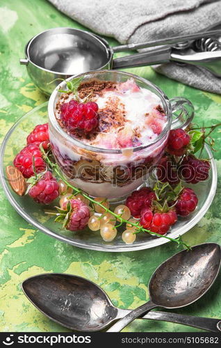 Raspberry ice-cream in mug. Raspberry ice cream with currants in glass cup.Sundae on rustic background.