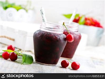 raspberry jam in glass bank and on a table