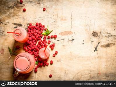 Raspberry juice in the pitcher and glasses. On a wooden table.. Raspberry juice in the pitcher and glasses.