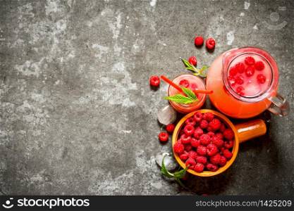 Raspberry juice with the berries and ice. On the stone table.. Raspberry juice with the berries and ice.