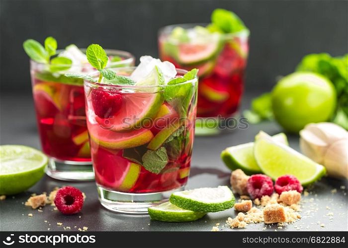 Raspberry mojito cocktail with lime, mint and ice, cold refreshing drink