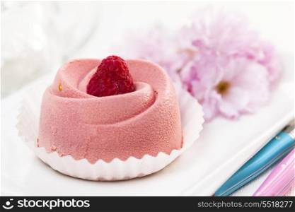 Raspberry mousse dessert. Closeup of pink raspberry mousse dessert with cherry blossom