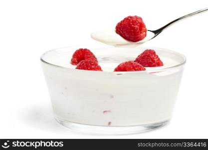 raspberry on a spoon over a dessert with raspberries. raspberry on a spoon over a dessert in a bowl with raspberries on white background
