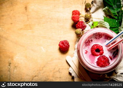Raspberry smoothie with different berries. On wooden background.. Raspberry smoothie with different berries.