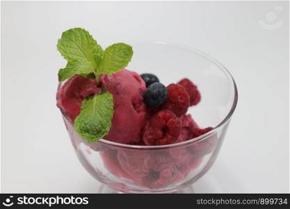 Raspberry Sorbet Topped with Mint Leaves on White Background