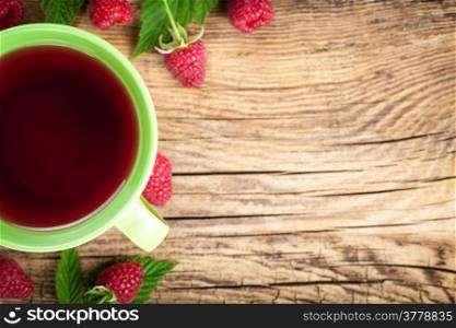 Raspberry tea with berry fruit on wooden table background. Copy space. Top view