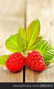 Raspberry with leafs on wooden table