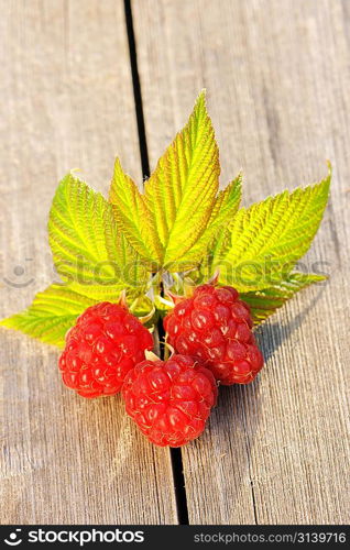 Raspberry with leafs on wooden table