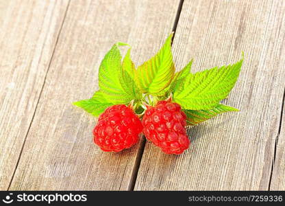 Raspberry with leafs on wooden table