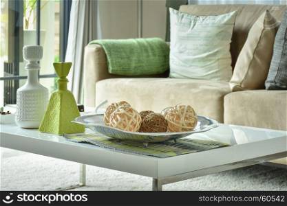 Ratten balls and vases on white top table with light brown sofa