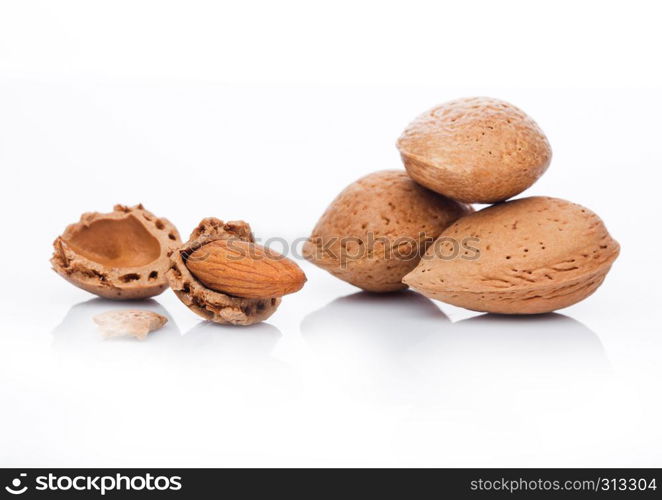 Raw almonds nuts with shell on white background with reflection