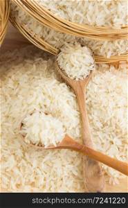 Raw and uncooked rice in wooden spoon,shallow Depth of Field,Focus on wooden spoon.. Raw and uncooked rice in wooden spoon.