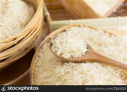 Raw and uncooked rice in wooden spoon,shallow Depth of Field,Focus on wooden spoon.. Raw and uncooked rice in wooden spoon.