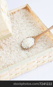 Raw and uncooked rice in wooden spoon,shallow Depth of Field,Focus on wooden spoon.. Raw and uncooked rice in wooden spoon.