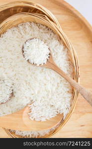 Raw and uncooked rice in wooden spoon,shallow Depth of Field,Focus on wooden spoon.. Raw and uncooked rice in wooden spoon.