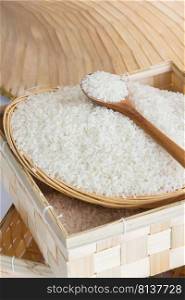 Raw and uncooked rice in wooden spoon,shallow Depth of Field,Focus on wooden spoon. . Raw and uncooked rice in wooden spoon.