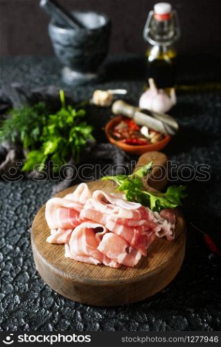 raw bacon on wooden board, bacon with salt and aroma spice