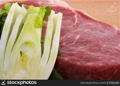 Raw beef and fennel. close up photo of a raw beef and a fennel