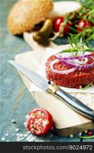 Raw beef burger for hamburger with vegetables on wooden table