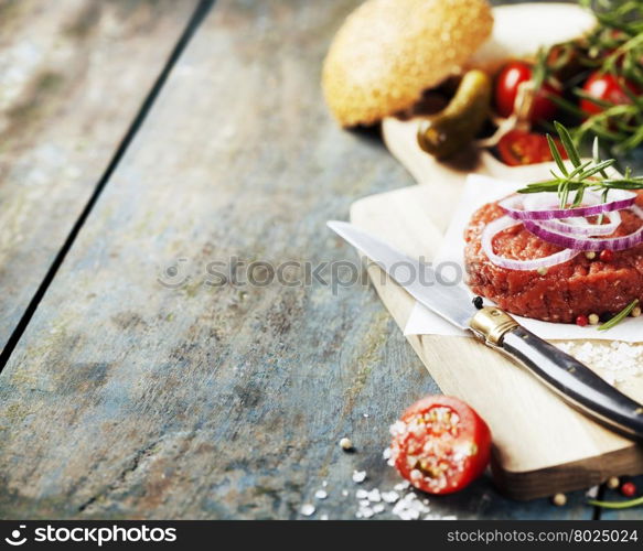 Raw beef burger for hamburger with vegetables on wooden table