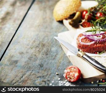Raw beef burger for hamburger with vegetables on wooden table