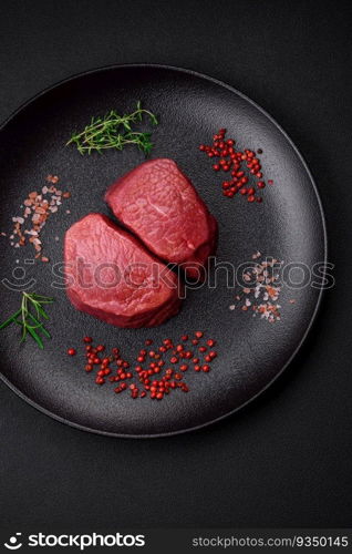 Raw beef eye steak round with salt, spices and herbs prepared for grilling on a textured background. Raw beef eye steak round with salt, spices and herbs