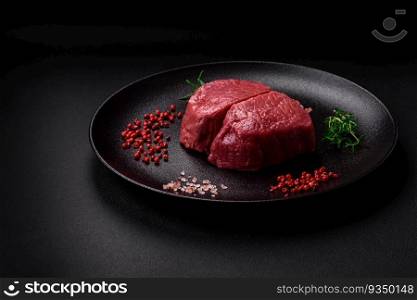 Raw beef eye steak round with salt, spices and herbs prepared for grilling on a textured background. Raw beef eye steak round with salt, spices and herbs
