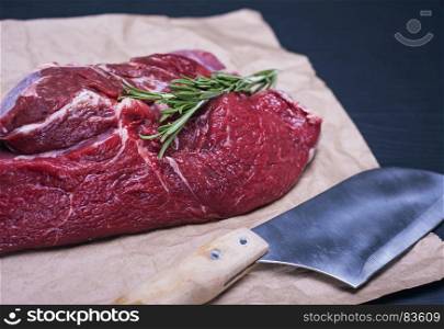 raw beef fillet on a brown sheet of paper, near the knife