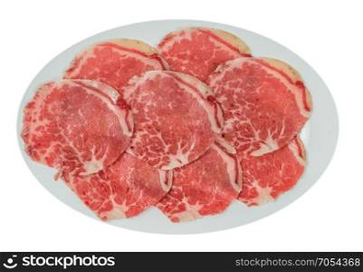 raw beef fillets on a plate . Top view of some raw beef fillets on a plate with white background