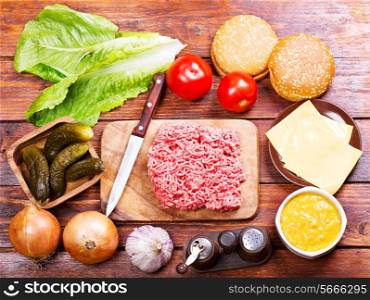 Raw beef for hamburger with vegetables on wooden table