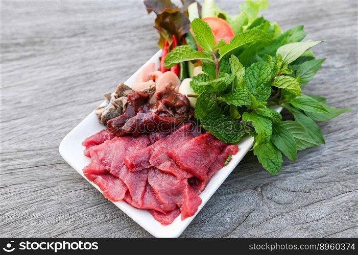 raw beef meat cuts slices on white plate and fresh vegetables fresh meat top view - beef  sashimi , beef liver asian thai food