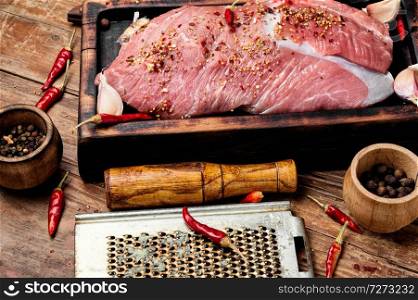 Raw beef meat on a cutting board.Beef with spice and on a wooden table. Raw beef meat