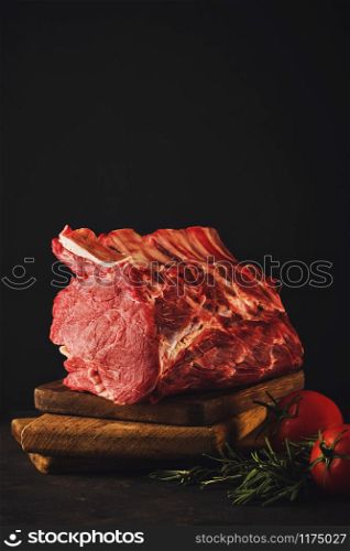 Raw beef meat on a wooden table close up on a dark background