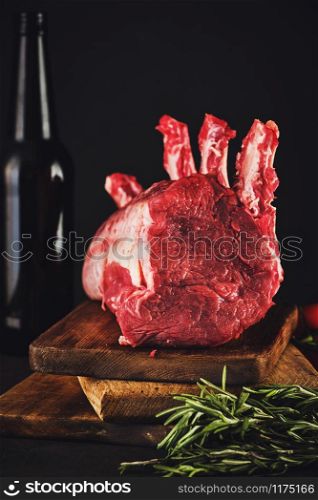 Raw beef meat on a wooden table close up on a dark background