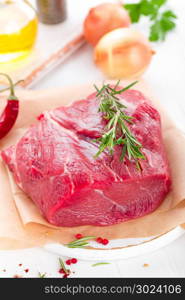 Raw beef meat tenderloin on white background with cooking ingredients closeup. Fresh beef meat on kitchen table