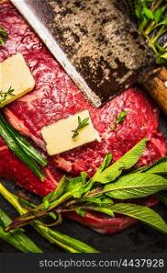 Raw beef meat with butter, old cleaver and fresh herbs, preparation for cooking, close up