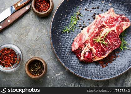 Raw beef meat with rosemary and spices. Piece of fresh raw beef meat