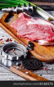 Raw beef on chopping board and kitchen utensils. Cooking meat dish