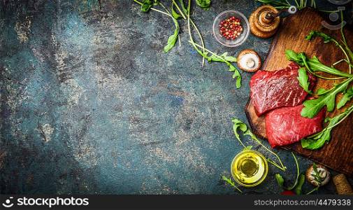 Raw Beef steak and fresh ingredients for cooking on rustic background, top view, banner. Healthy and diet food concept.