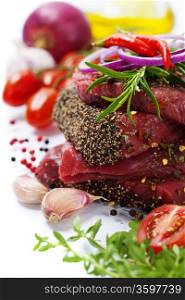 Raw beef steak and vegetables over white