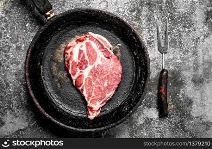 Raw beef steak in a pan. On rustic background.. Raw beef steak in a pan.