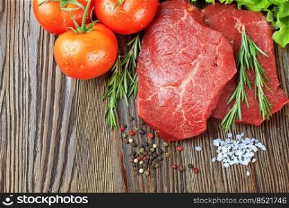 Raw beef steak on cutting board with vegetables and spices on brown wooden background. Beef steak, tomato, salad, garlic, rosemary, spice. Flat lay, top view, mockup with copy space for text. Raw beef steak with vegetables and spices