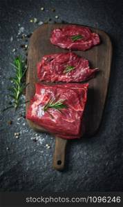 Raw beef steak with herb and spices / Fresh meat beef sliced on wooden cutting board background